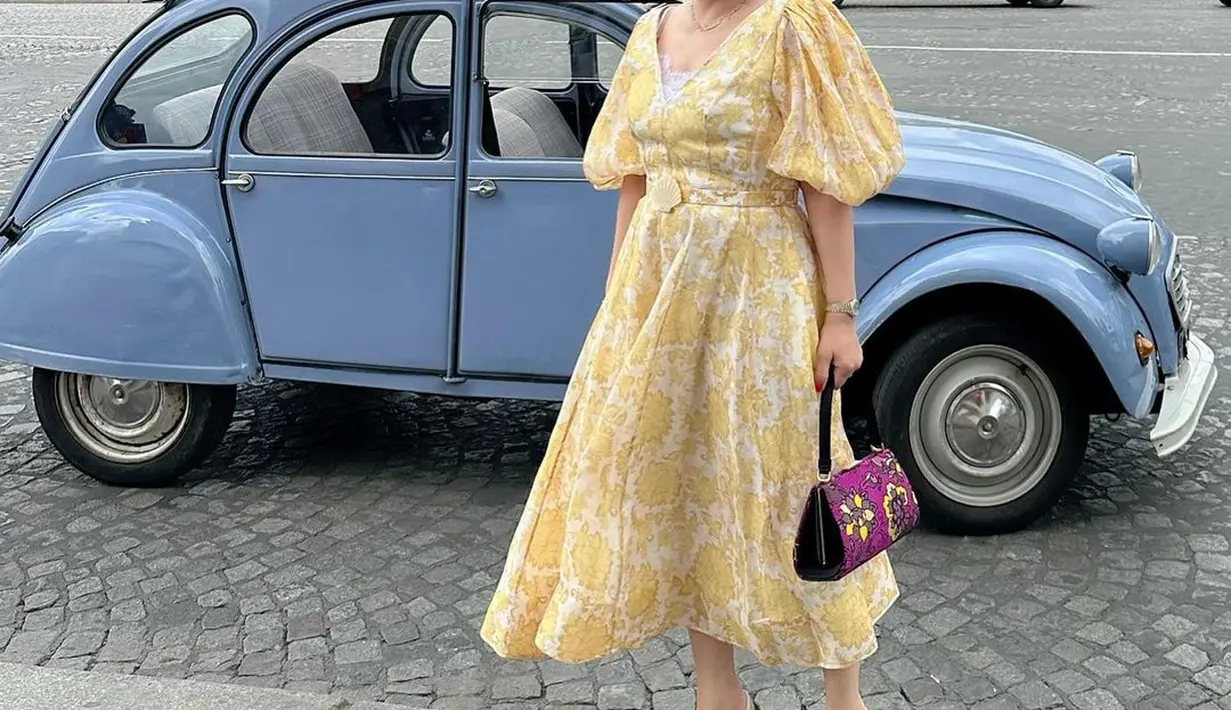 Yanti Airlangga tampil menggemaskan bak princess dengan dress kuning muda yang lembut. Dress ini memiliki detail lengan balon dan motif flora yang cantik. [Foto: Instagram]