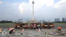 Para pekerja mengganti batu pelataran yang rusak di kawasan Monas, Jakarta, Kamis (10/11). Hal tersebut dilakukan untuk menjaga kawasan Monas agar tetap terawat dan nyaman bagi pengunjung. (Liputan6.com/Immanuel Antonius)