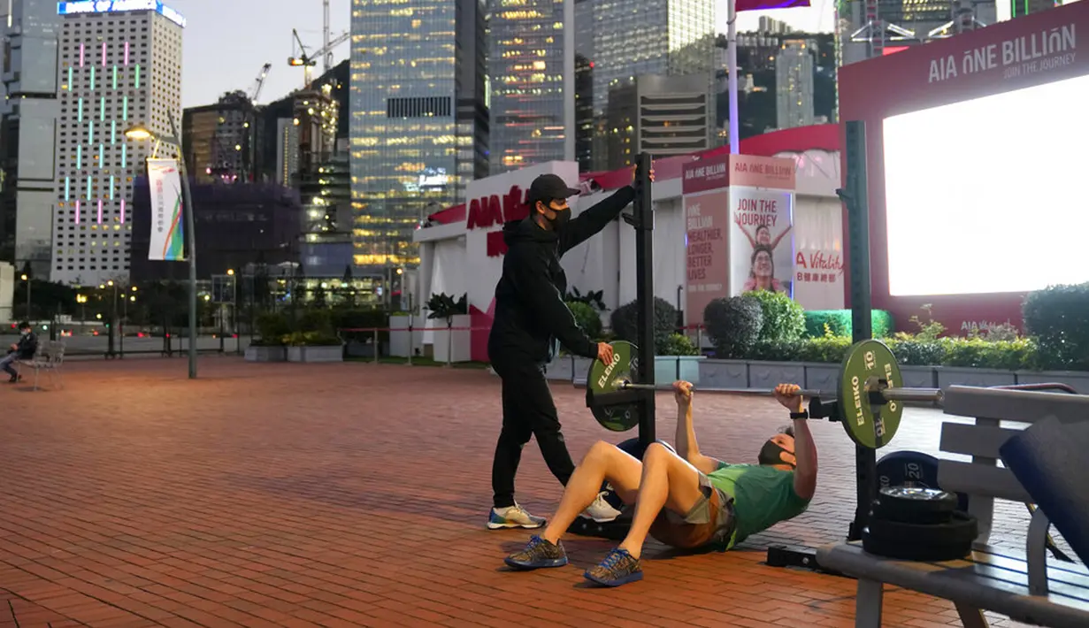 Orang-orang yang memakai masker berolahraga luar ruangan di Hong Kong, 8 Maret 2022. Pemerintah Hong Kong memperluas langkah-langkah jarak sosial, memaksa banyak fasilitas bisnis dalam ruangan seperti pusat kebugaran, salon, bar, dan spa tutup. (AP Photo/Kin Cheung)