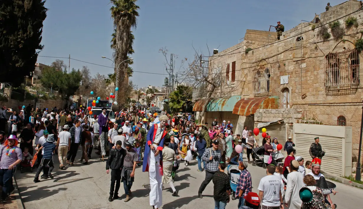 Kemeriahan saat warga Yahudi merayakan Hari Purim di Jalan al-Shuhada, Kota Hebron, Tepi Barat, Kamis (1/3). (AFP PHOTO/HAZEM BADER)