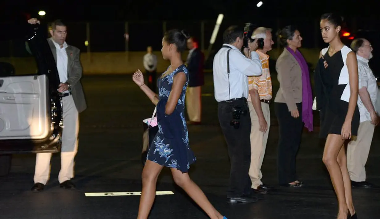 Saat mengetahui ada paparazzi yang selalu membidikkan kamera ke arahnya, putri sulung presiden Amerika Serikat Malia Obama dan teman-temannya segera pergi meninggalkan sebuah restoran di Southern California, Senin, (08/07/14), (AFP PHOTO/Jewel Samad)