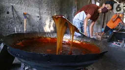 Pekerja mengaduk adonan dodol di pabrik dodol Betawi Mugi Jaya, Cilenggang, Tangerang Selatan, Rabu (13/5/2020). Produksi dodol selama pandemi Covid-19 tidak lebih dari 120 kg dibanding tahun lalu sebanyak 900 kg dodol. (Liputan6.com/Fery Pradolo)