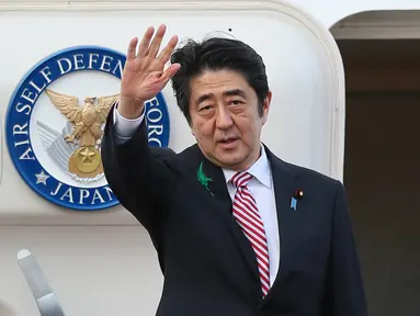 Dalam file foto pada 21 April 2015, Shinzo Abe yang masih menjabat sebagai Perdana Menteri Jepang melambai saat berangkat menuju Indonesia di Bandara Internasional Tokyo di Tokyo. Shinzo Abe dikabarkan telah meninggal dunia, setelah menjalani perawatan beberapa saat akibat akibat penembakan di Nara pada Jumat, 8 Juli 2022. (JIJI PRESS / AFP)