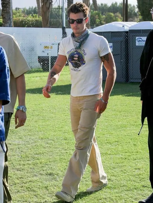 Terlihat pula Shawn Mendes yang tampil dengan t-shirt putih, scarf leher, dan long pants berwarna krem. [Foto: IG/evashionma].