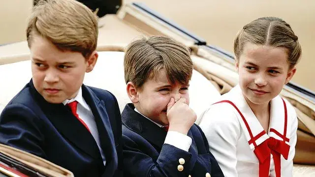 Pangeran Louis menutup hidungnya saat duduk diapit kedua kakaknya, Pangeran George dan Putri Charlotte saat menjadi bagian dalam arak-arakan di acara Trooping the Color 2023. (Twitter/@JohnMarkKarr)