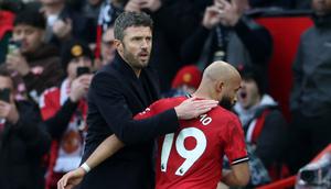 Pelatih interim Manchester United, Michael Carrick, memberi ucapan selamat kepada gelandang asal Kamerun Bryan Mbeumo saat meninggalkan lapangan setelah ditarik keluar dalam pertandingan Liga Inggris antara Manchester United dan Manchester City di Old Trafford, Manchester, Sabtu (17/1/2026). (Darren Staples / AFP)