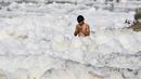 Seorang pria berdoa di Sungai Yamuna yang tercemar di New Delhi, Sabtu (8/7). Umat Hindu India mensucikan dua sungai di India yaitu Sungai Ganggga dan Yamuna. (DOMINIQUE FAGET / AFP)