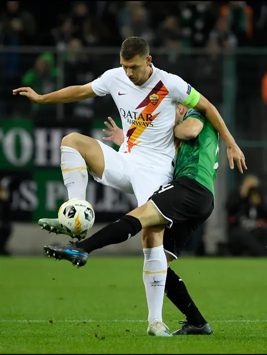 Gelandang AS Roma Bryan Cristante berebut bola dengan pemain Borussia Monchengladbach, Tony Jantschke dalam laga matchday keempat fase grup Liga Europa 2019-2020 di Stadion IM Borussia-Park, Kamis (7/11/2019). AS Roma takluk dari tim tuan rumah dengan skor 2-1. (INA FASSBENDER/AFP)