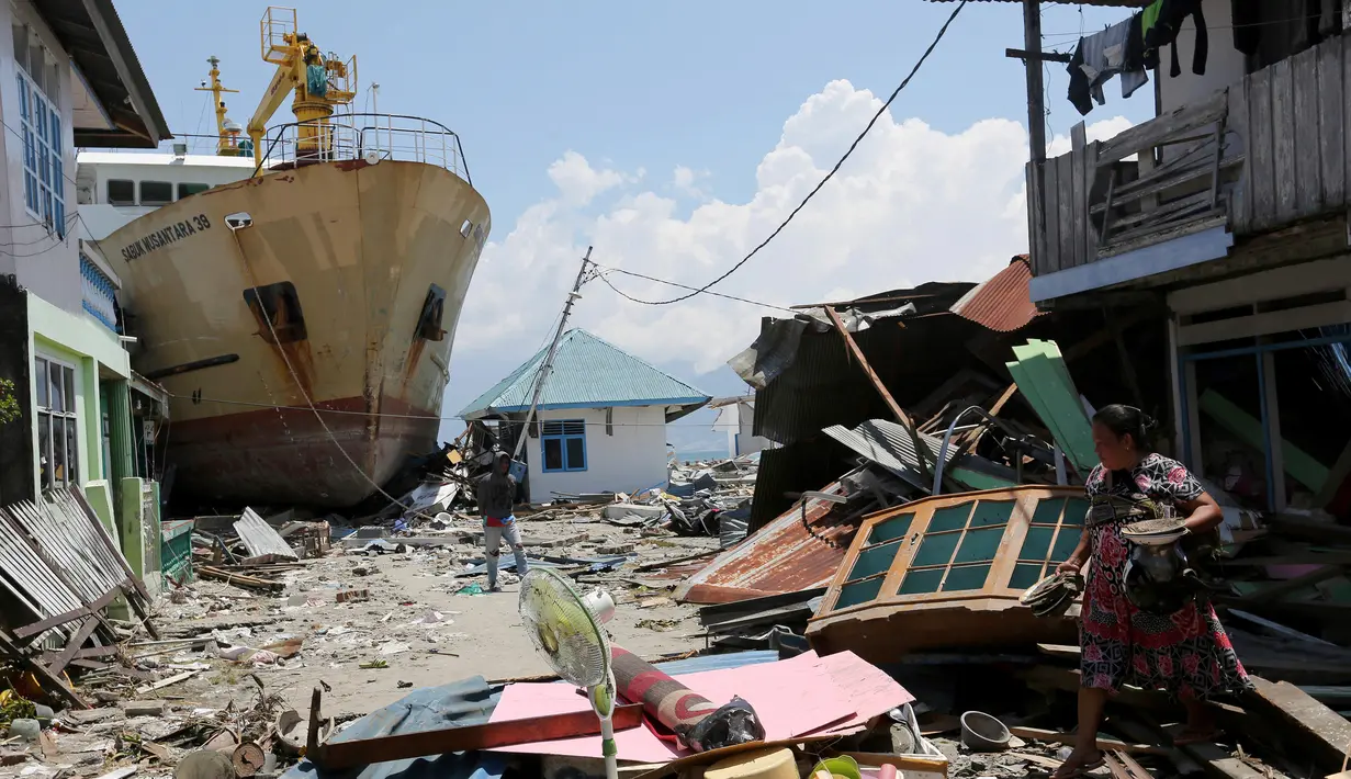 KM Sabuk Nusantara 39 terdampar di antara rumah warga setelah tsunami melanda Palu dan Donggala, Sulawesi Tengah, Selasa (2/10). KM Sabuk Nusantara 39 terhempas tsunami ke daratan sejauh 70 meter dari Pelabuhan Pantoloan. (AP Photo/Tatan Syuflana)