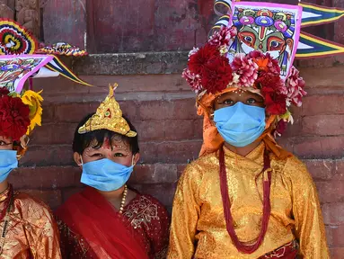Anak-anak Nepal mengenakan masker dan kostum sapi tradisional saat berpartisipasi dalam prosesi 'Gai Jatra', atau festival sapi, di Kathmandu, Selasa (4/8/2020). Festival ini untuk meminta keselamatan dan kedamaian bagi orang yang mereka cintai yang telah meninggal. (PRAKASH MATHEMA/AFP)