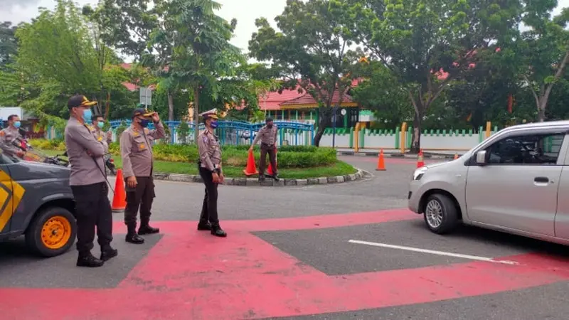 Personel Polresta Pekanbaru berjaga di Jalan Jenderal Sudirman untuk memeriksa kendaraan yang lewat.