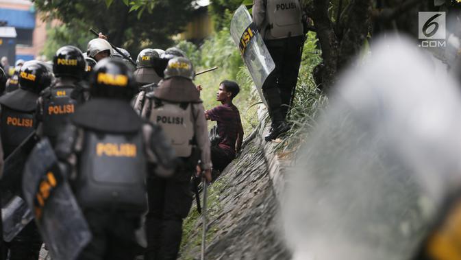 Polisi menginterogasi seorang pria saat tarjadi bentrok dengan massa di kawasan Petamburan, Jakarta Barat, Rabu (22/5/2019). Hingga pukul 11.30 WIB, situasi berangsur kondusif. (Liputan6.com/Faizal Fanani)