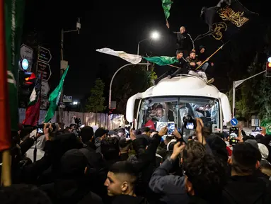 Kerumunan orang mengelilingi bus Palang Merah yang membawa tahanan Palestina yang dibebaskan dari penjara Israel, di Ramallah, Tepi Barat pada 26 November 2023. (FADEL SENNA/AFP)