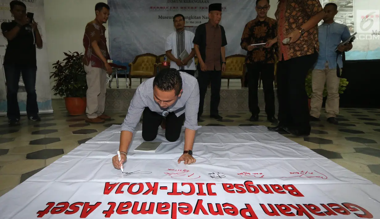 Ketua Federasi Pekerja Pelabuhan Indonesia Nova Hakim membubuhkan tanda tangan usai diskusi buku Melawan Konspirasi Global di Teluk Jakarta di Jakarta, Kamis (31/5). (Liputan6.com/Pool/Odoy)