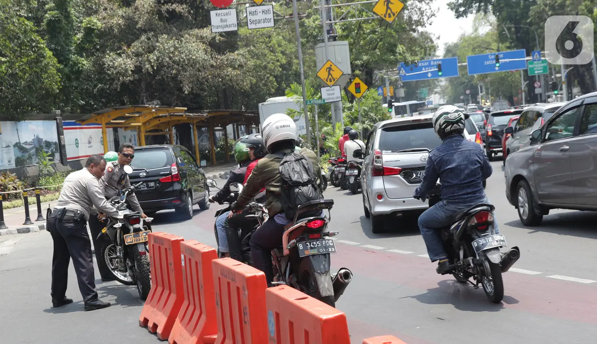 Sejumlah pengendara tertahan di belakang pembatas yang menutup jalan menuju Jalan Medan Merdeka Utara, Jakarta, Senin (14/10/2019). Menurut petugas jaga, penutupan ini antisipasi aksi unjuk rasa yang rencananya akan dilakukan di sekitar depan Istana Negara. (Liputan6.com/Helmi Fithriansyah)