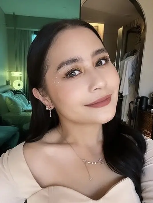 Rambut panjang hitamnya dibiarkan terurai dengan gaya belah dua tanpa poni.[@prillylatuconsina96]