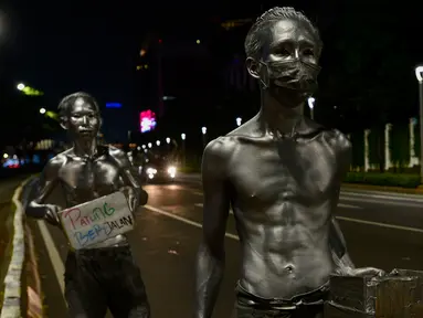 Manusia silver saat menghibur pengendara bermotor di perempatan kawasan Senayan, Jakarta, Sabtu (9/5/2020). Di tengah pandemi Covid-19 para manusia silver atau disebut "Patung Berjalan" itu tetap mengais rezeki untuk memenuhi kebutuhan sehari-hari (merdeka.com/Imam Buhori)