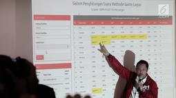 Anggota PDIP menjelaskan sistem penghitungan suara di sebuah layar di kantor DPP PDIP, Jakarta Pusat, Senin (22/4).  Dari penghitungan sementara tersebut, PDI Perjuangan unggul dengan 19,93%, Partai Golkar 13,62%, lalu Partai Gerindra 11,49%. (Liputan6.com/Faizal Fanani)