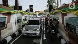Pengunjung bermobil dan bersepeda motor antre untuk masuk ke Taman Mini Indonesia Indah (TMII), Jakarta, Sabtu (15/5/2021). Selama libur Lebaran, pengelola TMII memberlakukan protokol kesehatan secara ketat. (Liputan6.com/Faizal Fanani)