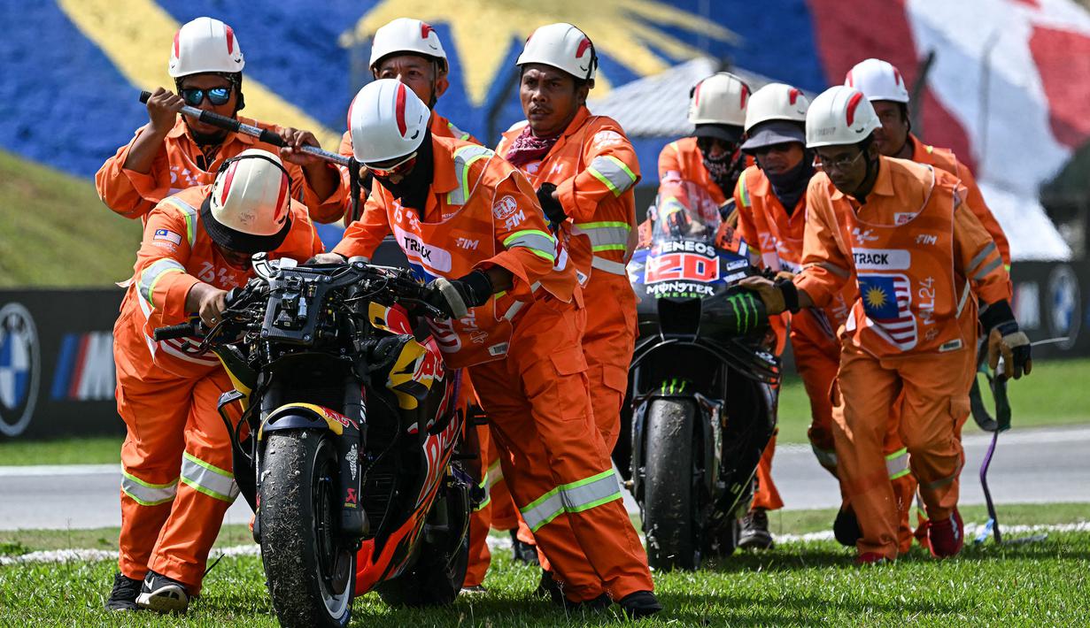 Sejumlah marshal melakukan evakuasi motor dari pembalap KTM, Brad Binder (kiri) dan motor pembalap Yamaha, Fabio Quartararo saat ajang balap MotoGP Malaysia 2024 yang berlangsung di Sirkut Sepang, Malaysia, Selasa (05/11/2024). (AFP/Mohd Rasfan)