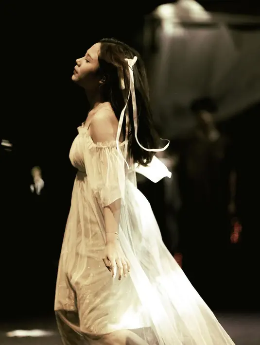 Pesona Nadin Amizah dibalut dress putih yang manis saat manggung. [Foto: Instagram/cakecaine]