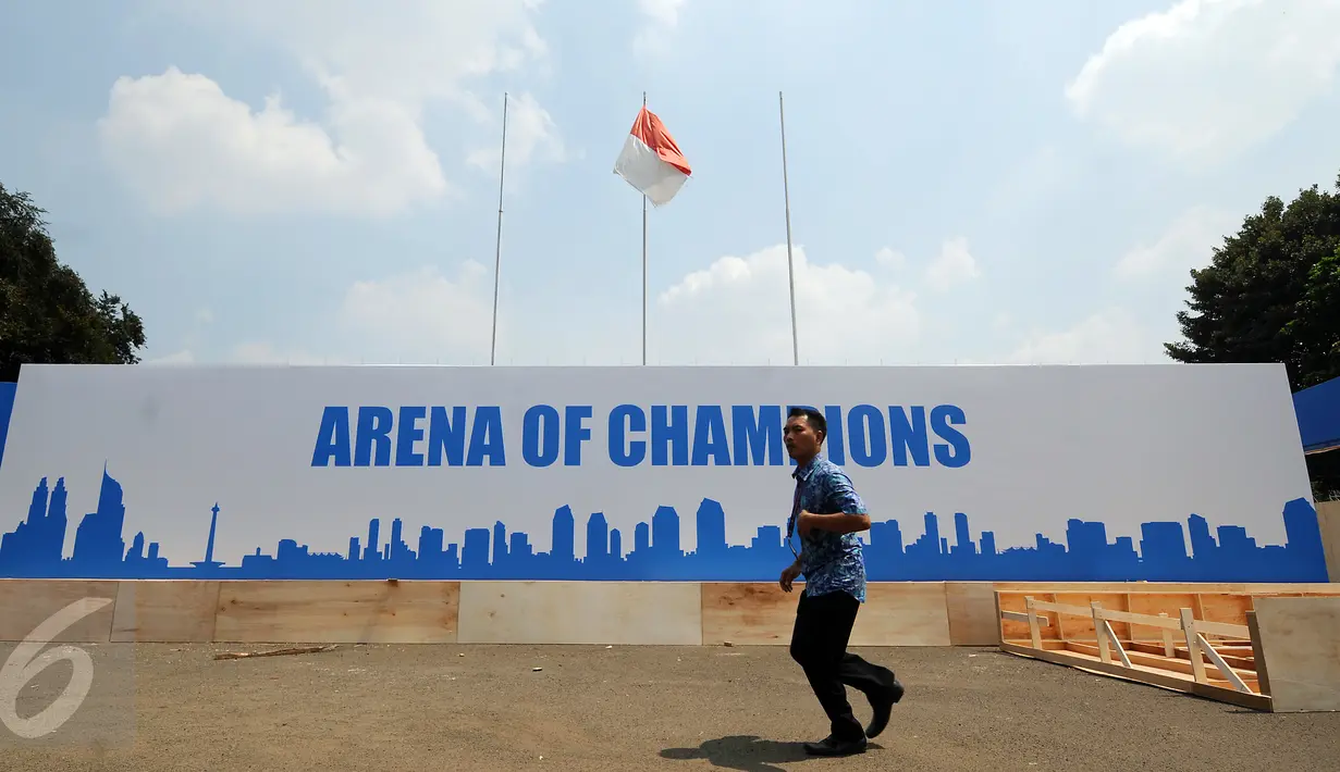 Seseorang melintas di depan banner arena champions di Istora Senayan, Jakarta, Jumat (7/8/2015). Jelang perhelatan Kejuaraan Bulutangkis Dunia 2015, sejumlah persiapan terus dilakukan pihak panitia pelaksana. (Liputan6.com/Helmi Fithriansyah)