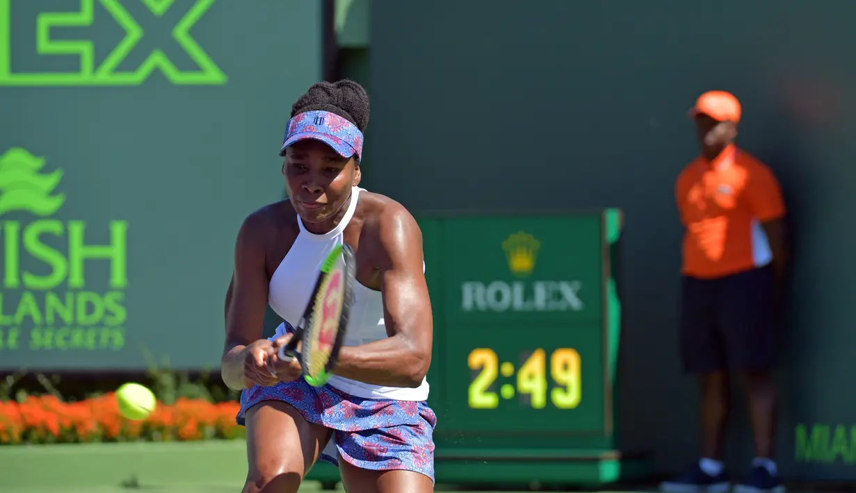 Unggulan delapan Venus Williams melakukan servis ke petenis Belanda, Kiki Bertens pada hari ketujuh Miami Terbuka di Crandon Park, Minggu (25/3).  Mantan petenis nomor satu dunia itu mengalahkan Kini Bertens dalam permainan tiga set. (AP/Lynne Sladky)