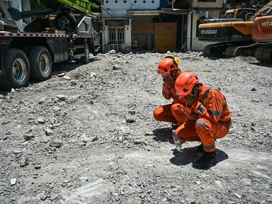 Personel dari tim dari Badan Nasional Pencarian dan Pertolongan (BASARNAS) berdoa setelah prosesi penutupan yang menandai berakhirnya operasi pencarian dan penyelamatan korban runtuhnya bangunan musala di Pondok Pesantren Al Khoziny di Sidoarjo, Jawa Timur, pada 7 Oktober 2025. (JUNI KRISWANTO/AFP)