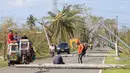 Sejumlah kendaraan melewati tiang listrik yang roboh akibat angin kencang yang disebabkan Topan Nock-ten di Kota Iriga Camarines Sur, Filipina tengah (27/12). Topan Nock-ten atau dikenal dengan Nina menerjang Filipina saat Natal. (REUTERS/Romeo Ranoco)