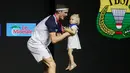 Momen kehangatan antara ayah dan anak perempuannya tersaji saat pebulu tangkis asal Denmark, Viktor Axelsen, merayakan gelar juara Indonesia Open 2022. Atlet berusia 28 tahun itu tampak memeluk dan menggendong anaknya untuk berselebrasi diatas podium. (Bola.com/Bagaskara Lazuardi)