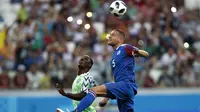 Pemain Islandia, Sverrir Ingason (kanan) membuang bola dari kejaran pemain Nigeria, Odion Ighalo pada laga grup D Piala Dunia 2018 di Volgograd Arena, Volgograd, Rusia, (22/6/2018). Nigeria menang 2-0.  (AP/Darko Vojinovic)