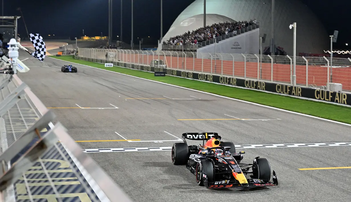 Pebalap Red Bull, Max Verstappen melintasi garis finis saat Formula 1 GP Bahrain 2023 yang berlangsung di Sirkuit Internasional Bahrin, Sakhir, Minggu (05/03/2023) WIB. (AFP/Andrej Isakovic)