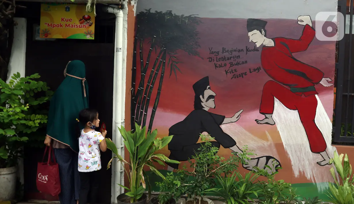 Warga beraktivitas di kawasan Kampung Sentra Kreatif, RW 006 Kota Bambu Selatan, Jakarta, Rabu (3/11/2021). Pengembangan kawasan perkampungan ini bertujuan untuk mengunggah semangat masyarakat agar melestarikan budaya. (Liputan6.com/Herman Zakharia)
