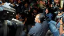 Bambang Widjojanto duduk di tangga saat menjawab pertanyaan wartawan terkait kedatangannya di kantor Bareskrim, Jakarta, Selasa (24/2/2015).(Liputan6.com/Andrian M Tunay)