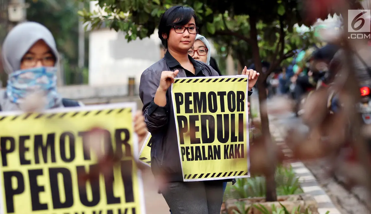 Sejumlah aktivis Koalisi Pejalan Kaki melakukan aksi peduli pejalan kaki di kawasan pedestrian Kasablanka, Jakarta, Kamis (22/8). Mereka menyerukan agar tidak menggunakan trotoar sebagai tempat parkir dan berjualan.(Liputan6.com/JohanTallo)