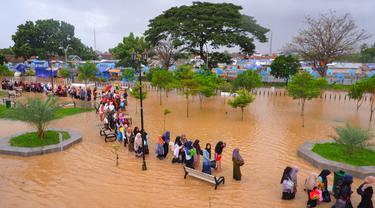 Warga mengarungi banjir saat mengungsi pasca banjir di Serang, Provinsi Banten (1/3/2022).  Banjir merendam Kota Serang akibat hujan deras yang turun sejak Senin malam (28/2/2022) hingga hari ini. (AFP/Dziki Oktomauliyadi)