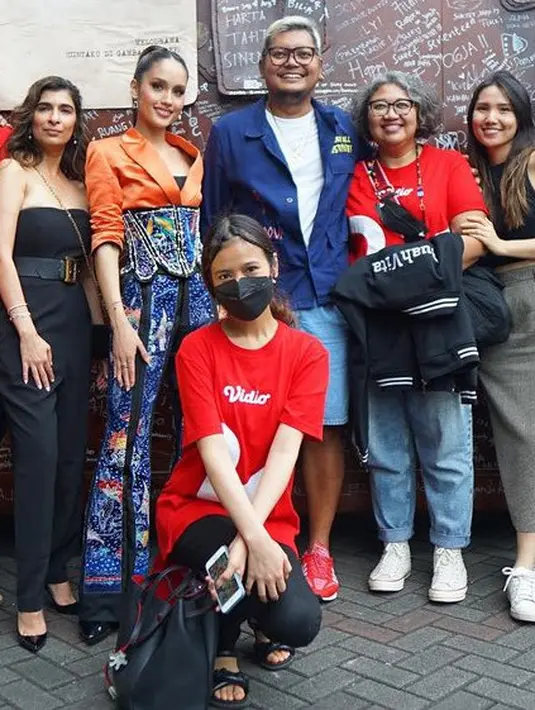 Mengenakan blazer orange dan kemben hitam Cinta memadukannya dengan korset dan celana panjang motif batik warna biru. [@claurakiehl]