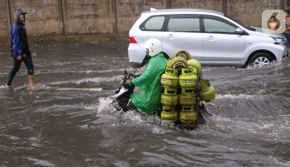 Pengendara terjebak banjir yang menggenangi jalan Bayangkara Pusdiklat, Kota Tangerang Selatan, Banten, Selasa (2/11/2021). BMKG mengeluarkan peringatan potensi cuaca ekstrem di wilayah Jakarta, Bogor, Depok, Tangerang, dan Bekasi (Jabodetabek). (Liputan6.com/Angga Yuniar)