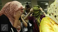 Para wanita asal Maroko menutupi wajahnya saat berada di kantor Imigrasi, Jakarta, Kamis (11/6/2015). Dalam keterangannya, pihak Imigrasi mengamankan sejumlah wanita yang diduga PSK asal Maroko di Bogor, beberapa waktu lalu. (Liputan6.com/Johan Tallo)