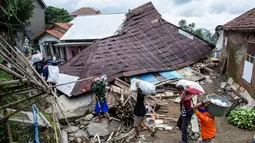 Badan Nasional Penanggulangan Bencana (BNPB) mencatat jumlah warga yang mengungsi meningkat. Tampak dalam foto, warga menyelamatkan barang-barang mereka setelah pergerakan tanah melanda permukiman mereka di desa Padasari, Tegal, Jawa Tengah, Senin 9 Februari 2026. (DEVI RAHMAN/AFP)