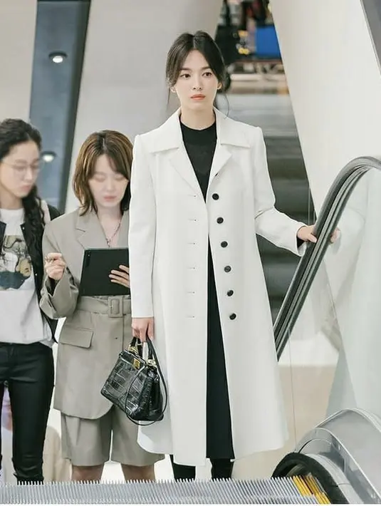 Outer putih dengan dress hitam juga bisa menginspirasimu tampil anggun. Dengan mambawa tas tangan hitam. Dok Micha