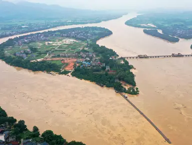 Foto hasil bidikan dari udara menunjukkan Sungai Rongjiang yang meluap di Wilayah Rong'an, Daerah Otonom Etnis Zhuang Guangxi, China selatan (11/7/2020). Hujan deras yang terus-menerus mengguyur Wilayah Rong'an menyebabkan level air Sungai Rongjiang naik. (Xinhua/Zhang Ailin)