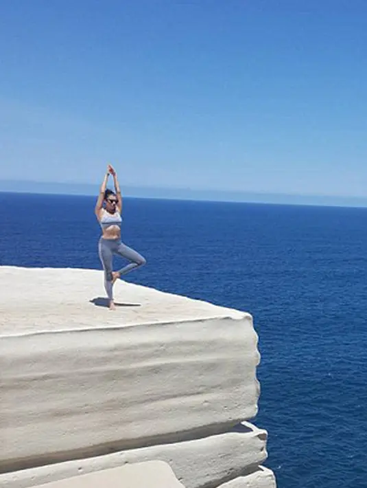 Seorang wanita melakukan gerakan Yoga disebuah tebing yang tinggi. Pecinta Yoga merasa nyaman dengan apa yang mereka lakukan tersebut. (Dailymail.co.uk)