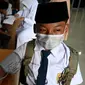 Seorang siswa sekolah menengah pertama menjalani pemeriksaan tekanan darah sebelum menerima dosis vaksin Sinovac pada acara vaksinasi virus corona COVID-19 di Blang Bintang, Provinsi Aceh, 21 September 2021. (CHAIDEER MAHYUDDIN/AFP)