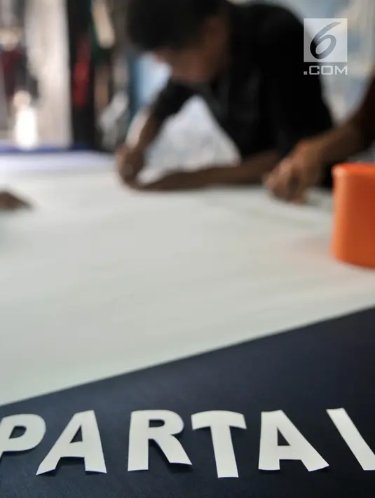 Pekerja mencetak huruf saat menyelesaikan sablon bendera partai politik di Percetakan Andalas Jaya, Jakarta, Rabu (2/1). Pedagang mengaku pemesanan naik hingga 60 persen dari bulan biasa. (Merdeka.com/Iqbal Nugroho)