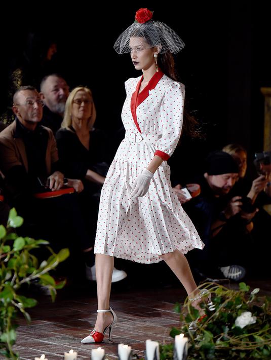 Bella Hadid berjalan di catwalk untuk show Rodarte pada New York Fashion Week: The Shows di New York City, Selasa (11/2/2020). Bella Hadid seolah-olah kembali ke era tahun 50an dalam balutan gaun polkadot merah dan putih dengan kerudung yang menutupi wajahnya. (Dimitrios Kambouris/Getty Images/AFP)