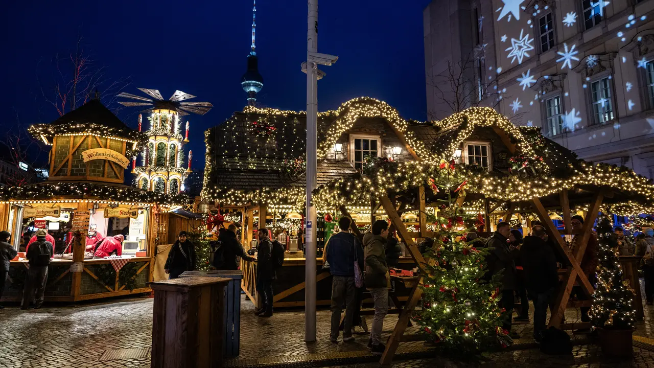 Pengunjung memadati stan di pasar Natal di Forum Humboldt Berlin, dengan Menara TV terlihat di latar belakang pada tanggal 19 Desember 2024 di Berlin, Jerman, selama musim liburan. John MACDOUGALL / AFP