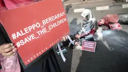 Peserta melakukan teatrikal saat aksi solidaritas peduli Suriah bertema 'Stop Suriah Memerah Darah' di car free day Bundaran HI, Jakarta, Minggu (8/5). Selain di Jakarta, aksi ini dilakukan pula di sejumlah kota besar lain. (Liputan6.com/Faizal Fanani)