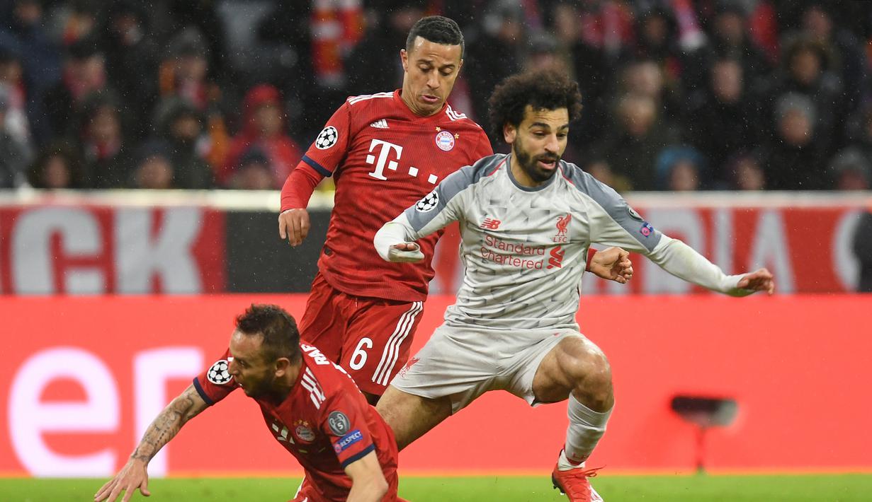 Aksi Mohammed Salah lewati Rafinha pada leg kedua, babak 16 besar Liga Champions yang berlangsung di Stadion Allianz Arena, Munchen, Kamis (14/3). Liverpool menang 3-1. (AFP/ Christof Stache)