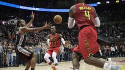 Aksi pemain Atlanta Hawks, Dennis Schroder (tengah) mengecoh pemain Spurs, Kawhi Leonard (kiri) pada lanjutan NBA basketball game di Philips Arena, (01/01/2017). Atlanta menang 114-112. (AP/John Amis)